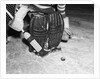 1940s 1950s close-up of padded goalie shown waist-down holding stick with puck in front of him by Anonymous