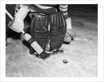 1940s 1950s close-up of padded goalie shown waist-down holding stick with puck in front of him by Anonymous