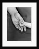 1950s close-up of baby holding mother's thumb by Anonymous