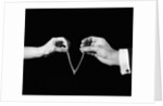 1940s man's & woman's hands pulling on either side of wishbone by Anonymous
