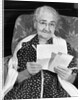 1960s elderly woman in polka-dotted dress & shawl reading letter by Anonymous