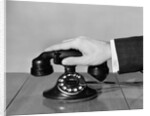 1930s 1940s man's hand on telephone by Anonymous