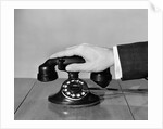 1930s 1940s man's hand on telephone by Anonymous