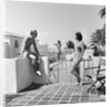 1930s man woman wearing bathing suits on terrace overlooking swimming pool woman on diving board by Anonymous