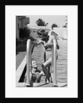 1930s woman wearing one piece bathing suit climbing out of swimming pool looking down at man smiling by Anonymous