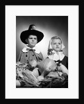 1950s boy & girl in pilgrim costumes with harvest arrangement on table by Anonymous