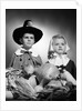 1950s boy & girl in pilgrim costumes with harvest arrangement on table by Anonymous