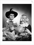 1950s boy & girl in pilgrim costumes with harvest arrangement on table by Anonymous