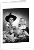 1950s boy & girl in pilgrim costumes with harvest arrangement on table by Anonymous