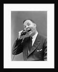 1930s man in suit laughing talking on telephone by Anonymous