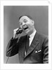1930s man in suit laughing talking on telephone by Anonymous