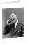 1930s man in suit laughing talking on telephone by Anonymous