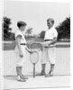 1920s 1930s two boys tennis match holding rackets measuring net height by Anonymous