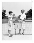 1920s 1930s two boys tennis match holding rackets measuring net height by Anonymous
