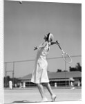 1930s woman playing tennis about to hit ball with racket by Anonymous