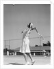 1930s woman playing tennis about to hit ball with racket by Anonymous