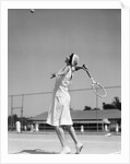 1930s woman playing tennis about to hit ball with racket by Anonymous