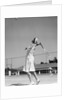 1930s woman playing tennis about to hit ball with racket by Anonymous