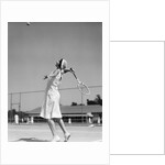 1930s woman playing tennis about to hit ball with racket by Anonymous