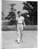 1930s man walking across tennis court holding tennis racket & balls by Anonymous