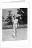1930s man walking across tennis court holding tennis racket & balls by Anonymous