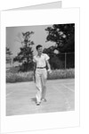 1930s man walking across tennis court holding tennis racket & balls by Anonymous