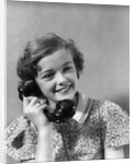 1930s teen girl smiling brunette print dress talking on telephone by Anonymous