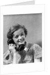 1930s teen girl smiling brunette print dress talking on telephone by Anonymous