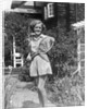 1930s teen girl brunette on sidewalk of house holding tennis racket wearing shorts by Anonymous