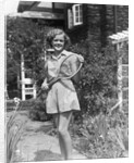 1930s teen girl brunette on sidewalk of house holding tennis racket wearing shorts by Anonymous