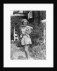 1930s teen girl brunette on sidewalk of house holding tennis racket wearing shorts by Anonymous