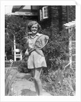 1930s teen girl brunette on sidewalk of house holding tennis racket wearing shorts by Anonymous