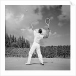 1930s back view of man playing tennis about to hit the ball summer outdoor by Anonymous