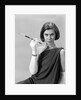 1960s formally elegantly dressed young woman looking at camera with a cigarette holder wearing long white gloves by Anonymous