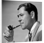 1950s frowning businessman in jacket and tie smoking a pipe by Anonymous