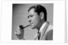 1950s frowning businessman in jacket and tie smoking a pipe by Anonymous