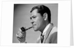 1950s frowning businessman in jacket and tie smoking a pipe by Anonymous