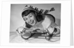 1950s smiling young teenage woman posing on sled in winter wool knit clothes looking at camera by Anonymous