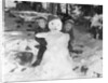 1950s 1960s smiling boy and girl building a snowman together in snowy woods by Anonymous