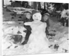 1950s 1960s smiling boy and girl building a snowman together in snowy woods by Anonymous