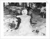 1950s 1960s smiling boy and girl building a snowman together in snowy woods by Anonymous
