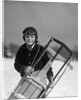 1920s 1930s smiling boy wearing aviator goggles leather flying helmet holding sled standing in snow field looking at camera by Anonymous