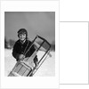 1920s 1930s smiling boy wearing aviator goggles leather flying helmet holding sled standing in snow field looking at camera by Anonymous