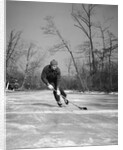1940s man playing ice hockey on frozen lake controlling puck with stick by Anonymous