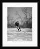 1940s man playing ice hockey on frozen lake controlling puck with stick by Anonymous