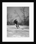 1940s man playing ice hockey on frozen lake controlling puck with stick by Anonymous