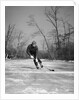 1940s man playing ice hockey on frozen lake controlling puck with stick by Anonymous