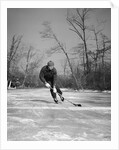 1940s man playing ice hockey on frozen lake controlling puck with stick by Anonymous