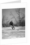 1940s man playing ice hockey on frozen lake controlling puck with stick by Anonymous