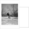1940s man playing ice hockey on frozen lake controlling puck with stick by Anonymous